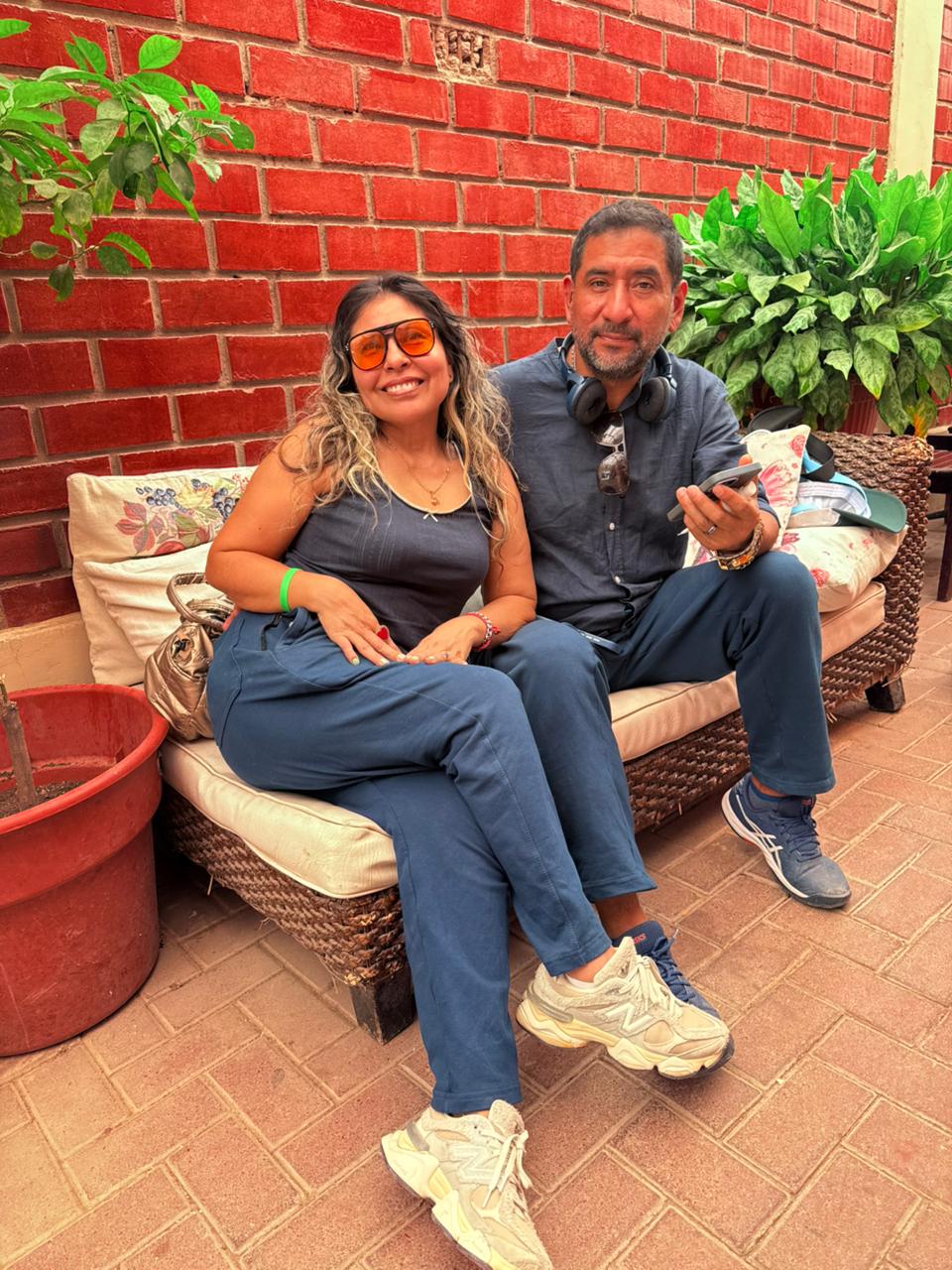 Los dos sentados juntos en un sofá frente a una pared de ladrillo